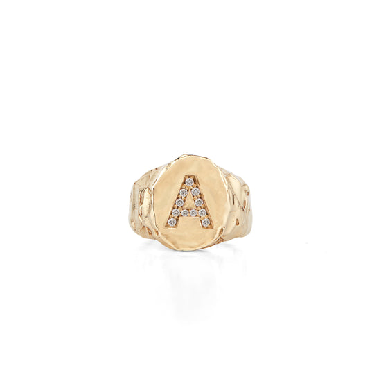 The Violet Signet Ring is made in 14-karat gold with a letter set with diamonds in Fie Isolde's raw signature look. It is an amazing statement piece that you will never take off once put on. The cigar shaped band makes it comfortable to wear but still maintain the chunky look. The signet ring has a high polished finish making the gold look like liquid. PRODUCT DETAILS:   Ring in 14-karat gold with diamonds.  Handmade in Los Angeles 